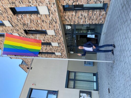 Markus Mücke hisst die Regenbogen Flagge vor dem Rathaus