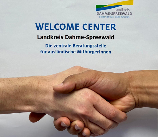 Zu sehen ist ein Handshake im Welcome Center.