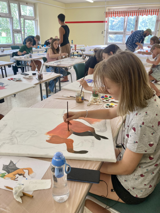 Zu sehen sind die TeilnehmerInnen beim malen während der XXI. Internationalen Jugendbegegnung im KIEZ Frauensee.